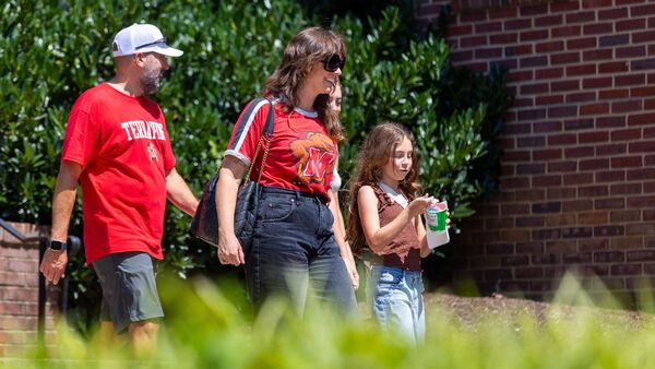family smiling and walking outdoors