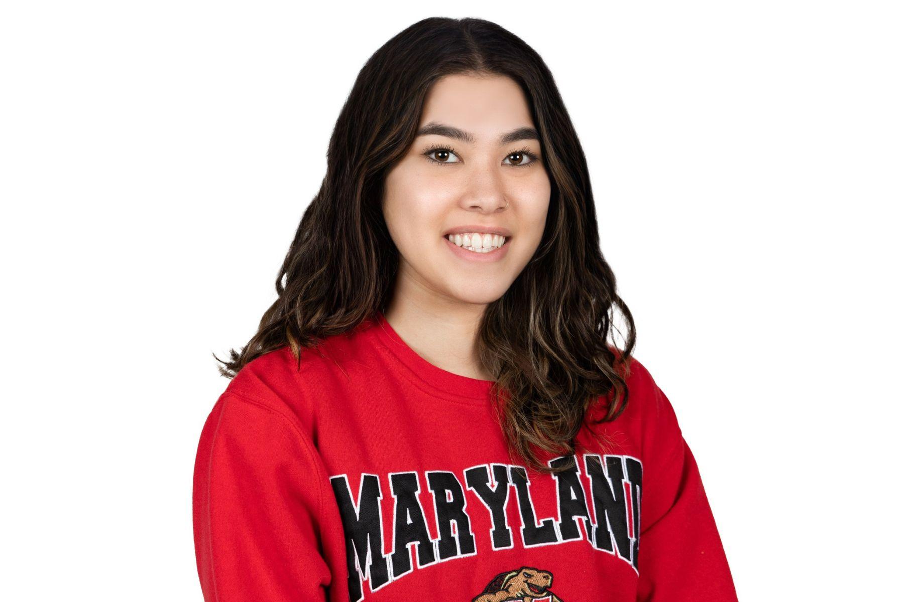 Rosie is wearing a red Maryland sweatshirt and is smiling at the camera