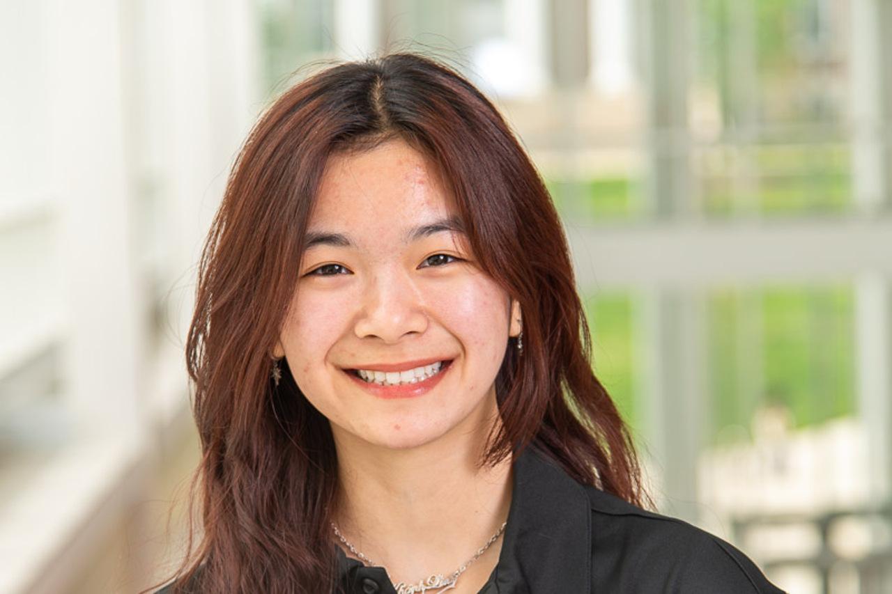 TA Lin with silver dangle earrings and chocolate brown wavy hair