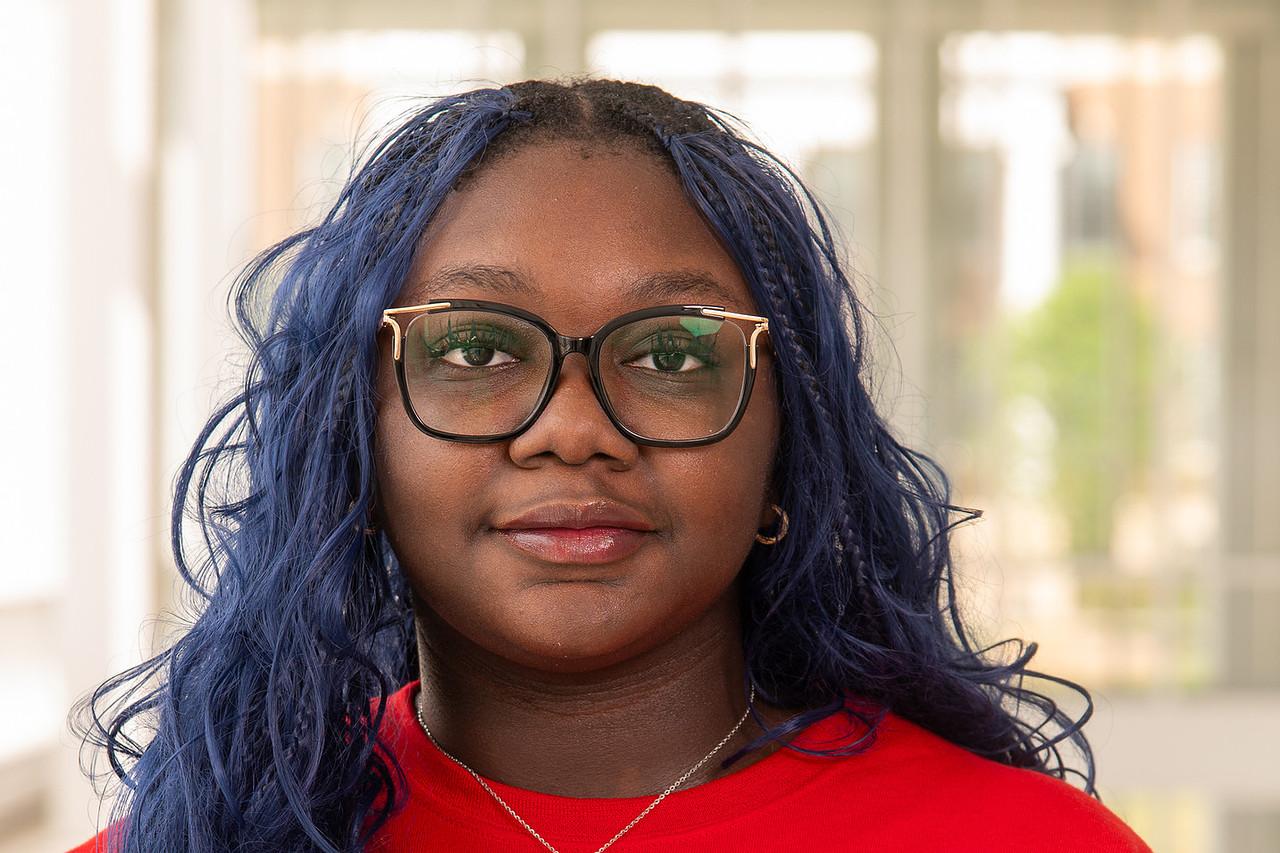 Transition Mentor Angie Odewole in a red UMD t-shirt and black framed glasses