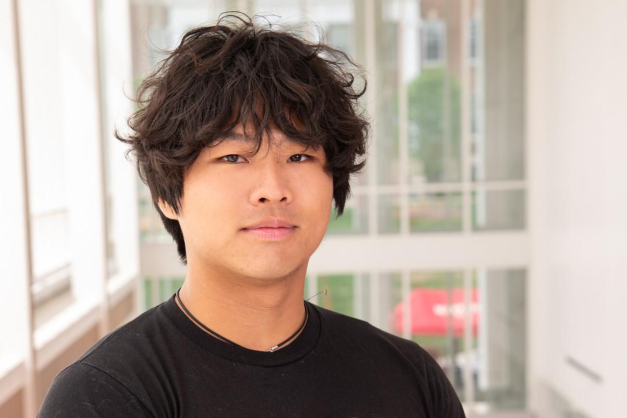 Transition Council Member Kyle Goh in a black Univeristy of Maryland t-shirt with a Red Maryland about the UMD flag in the globe shape. 